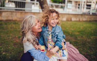 Loving grandmother and granddaughter playing and laughing together in garden